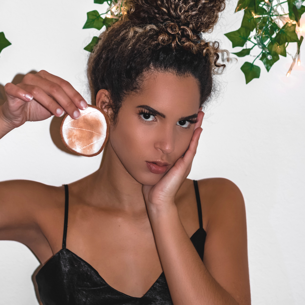 makeup remover pads from skin cleansing kit held by model